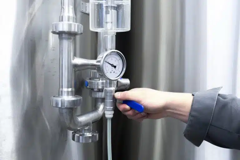 a handyman turning the tube valve on the factory